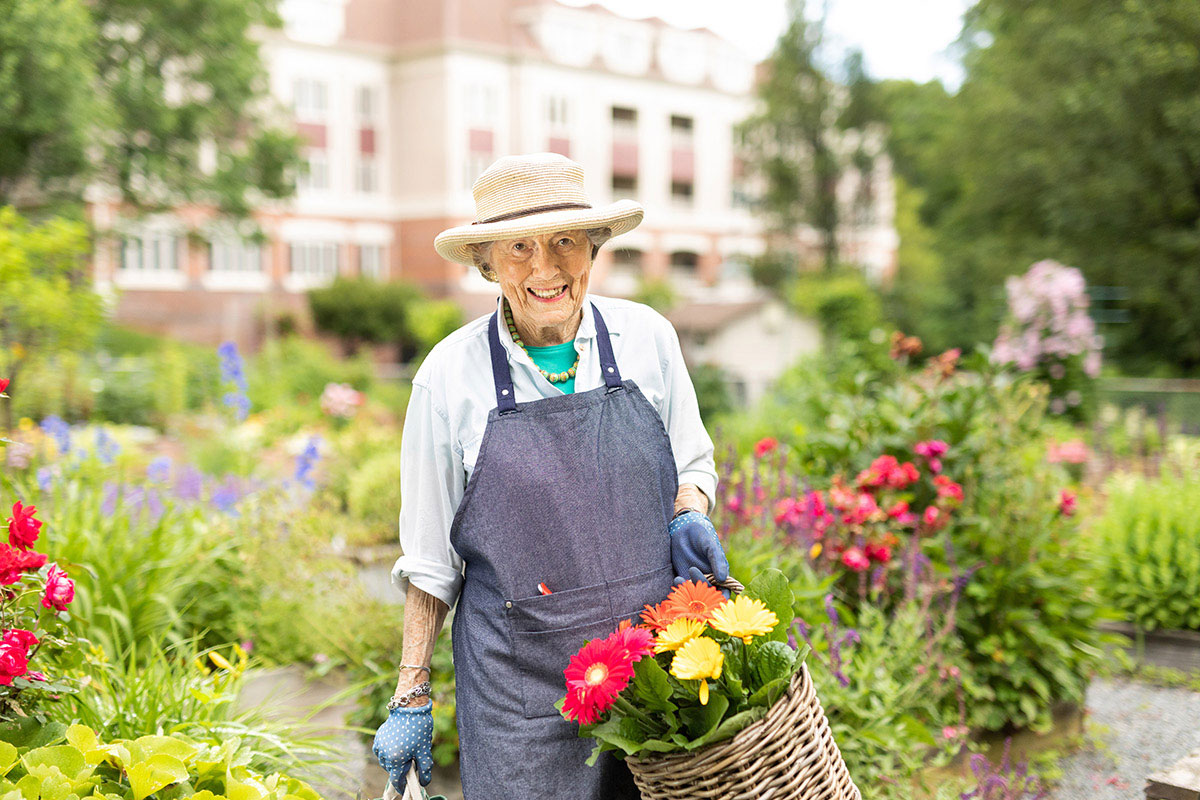 A smiling woman working in the garden