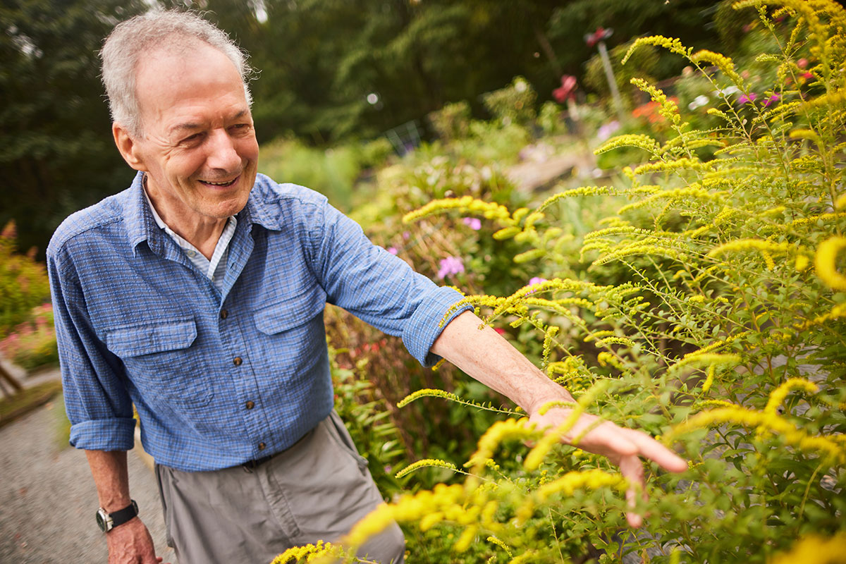 A man smiling while in the garden